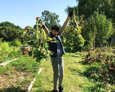 a young man holding up some vegetables